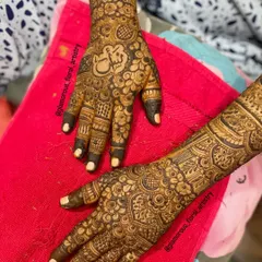 Full coverage bridal mehendi for Afra, featuring a beautiful Ganesha motif on the palm, surrounded by delicate floral and paisley patterns.