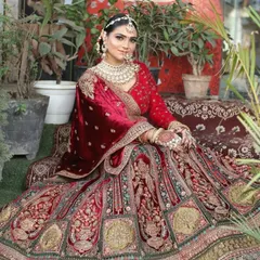 A full view of a magnificent red velvet bridal lehenga. The detailed embroidery and rich fabric make it a truly royal choice for your wedding ceremony.