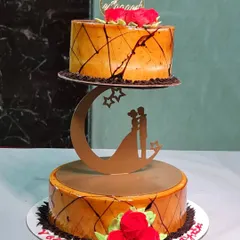 A stunning two-tier engagement cake with a floating design. The top tier rests on a romantic moon and stars separator, perfect for celebrating a couple's special moment.