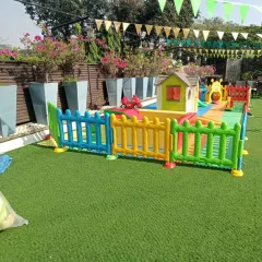 This rooftop terrace was turned into a child's dream with a playhouse, a small ball pit, and ride-on toys. The artificial grass and colorful fencing create a safe, contained area for fun under the open sky.