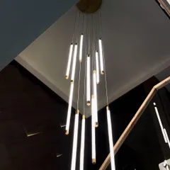 Our height-adjustable Wand Chandelier brings customizable brilliance to any space. This installation in a modern home demonstrates how the fixture can be adapted to create a dramatic, cascading effect over a staircase, making it a true centerpiece.