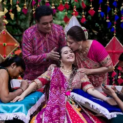 A heartwarming photo of the bride being showered with love and kisses from her parents during her Mehendi ceremony.
