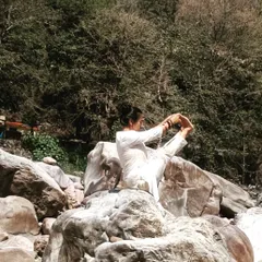 Yoga on the rocks by the river Ganga. Holding a balancing pose here reminds me of the constant flow and stability of nature.