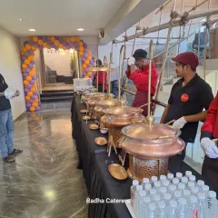 A wider view of our buffet line at a corporate opening. You can see the full length of the setup, including our traditional copper serving pots and arrangements for water. We can scale our services for large gatherings while maintaining high standards of presentation and hygiene.