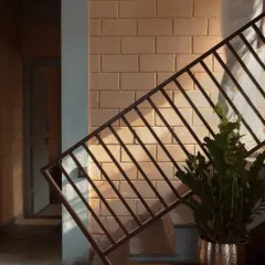 The interplay of light and shadow on an exposed brick wall reveals the raw honesty of the materials, creating a warm and embracing atmosphere.