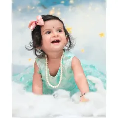 A close-up from a 'Moon & Stars' session, showing a beautiful, happy expression. I focus on capturing these sweet, fleeting moments of wonder against a dreamy, cloud-like backdrop.
