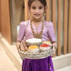 My cutest client wishing everyone a happy Makar Sankranthi. She is wearing a custom pattu pavadai with a lavender blouse and a rich purple skirt with a traditional elephant motif border.