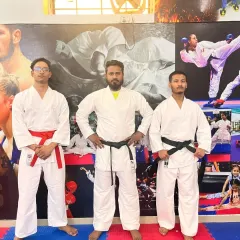 Standing with my senior karate students. As a coach, my job is to guide them on their path from beginner to black belt and beyond.
