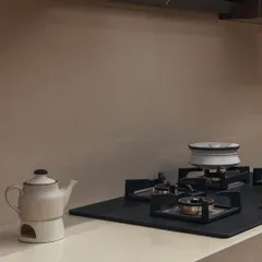 Even the smallest details contribute to the overall harmony. A minimalist kettle and a small plant on the clean countertop against a neutral backsplash create a sense of calm and order.