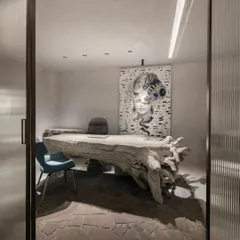 A desk carved from a massive, reclaimed tree trunk becomes the centerpiece of this studio. It's a bold expression of identity, where the raw power of nature is transformed into a functional work of art.
