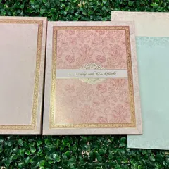 A beautiful invitation set in pastel pink and blue, with delicate floral patterns and gold foil borders.