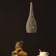 A single teardrop-shaped pendant with a unique, textured ceramic finish. This fixture is perfect for adding an artisanal touch over a small table.