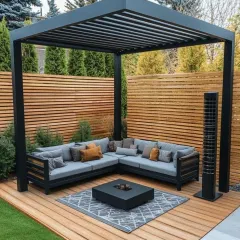 For this backyard project, we constructed a minimalist black pergola over a wooden deck to create a defined outdoor living room. The space is furnished with a large, weatherproof sectional sofa and a central fire pit table, perfect for social gatherings.