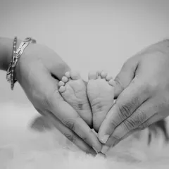 The iconic shot of a newborn's feet held in their parents' hands, made even more classic and emotional in black and white.