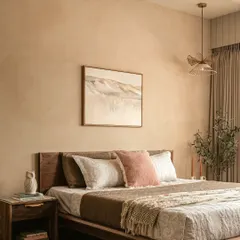 In this bedroom, the walls are treated with a textured lime-wash effect paint, creating a surface that breathes and plays with light. The low walnut bed and integrated nightstand enhance the room's organic, modern feel.