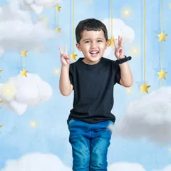 A joyful boy stands amidst a dreamy backdrop of clouds and stars, making a peace sign with both hands, perfectly capturing the theme of reaching for the stars.