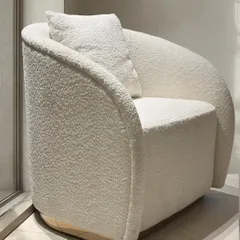 This angle showcases the continuous curve of the armchair's back and arms. The seamless design, combined with the solid, upholstered base, gives the piece a grounded yet elegant presence suitable for modern interiors.