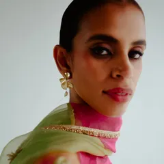 A close-up beauty shot for Esha Arora's collection. The focus is on the model's expression, the delicate earring, and the rich colors of the dupatta.