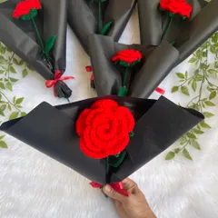 A collection of single red crochet roses, each wrapped in stylish black paper. These were so popular for Valentine's Day and make a great gift for friends and family.