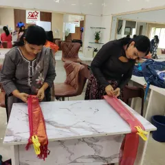 Hands-on practice is the core of my teaching. Here, students in my saree draping class are learning to create perfect pleats using my table-top method, ensuring each fold is precise.