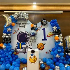 A closer view of the astronaut backdrop for Nick's party, showing the cute character and planet details.