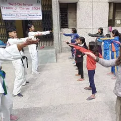 Our senior students help teach basic blocking techniques to the participants of the girls' self-defense camp.
