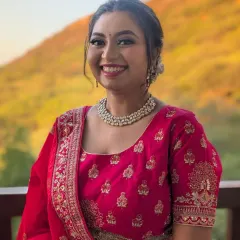A happy client smiling for the camera. This soft glam look with a pink lehenga is perfect for a family member attending a wedding, providing a fresh and elegant appearance.