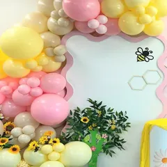 A detail shot of the balloon arch, showing the soft color palette and flower-shaped balloon clusters.