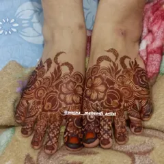 A rich, dark stain on a detailed floral foot mehendi design.