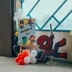 Welcome to the superhero headquarters! This entrance setup features a personalized welcome sign and a life-sized Spider-Man cutout, ready to swing into the party.