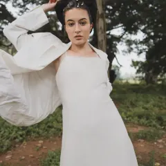 The 'SOLARA' series was about capturing a sense of ethereal movement. This look features a simple white dress layered with a flowing white blazer, creating a dynamic shape against the natural backdrop.