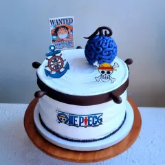 Another view of the "One Piece" cake, showing the ship's wheel details on the side.