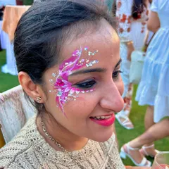 A delicate and dreamy floral design using shades of pink and white, accented with sparkling rhinestones. This is a perfect example of the kind of elegant face art you can offer for high-end parties and bridal events.