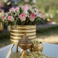 A close-up of the decor for a 'Pink Paradise' wedding. A brass incense burner, a bowl of jasmine, and a bouquet of pink roses create a sensory experience that is both visual and fragrant.