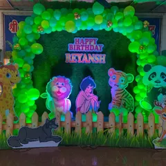 A fun Jungle Book and Lion King theme party setup. I used a green balloon arch over a grass-like backdrop, a wooden picket fence, and cutouts of favorite characters like Mowgli, Simba, and a panda to create a wild adventure.