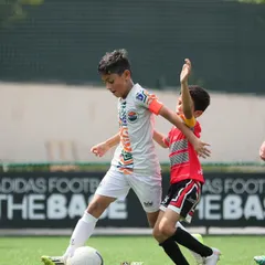 An action shot from a DPDL match, showing one of our players skillfully shielding the ball from a defender.