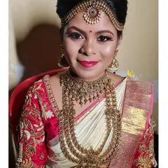 A portrait of Shruthi in her complete muhurtham attire. Her traditional look features layered gold necklaces and a radiant smile.