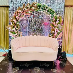 This couple's seating combines a shimmering silver sequin wall with a boho-style floral arch. The blush pink sofa adds a soft touch, making it a perfect photo-op for a glam Sangeet or Engagement.