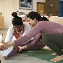 Working closely with a student in a forward fold. My goal is to provide personalized guidance and support, helping each person progress safely on their own journey.