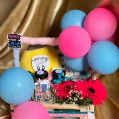 A vibrant gender reveal hamper decorated with pink and blue balloons. Inside the crate, I've included fresh flowers, a "Coming Soon" plush toy, and small gift jars to celebrate the parents-to-be.