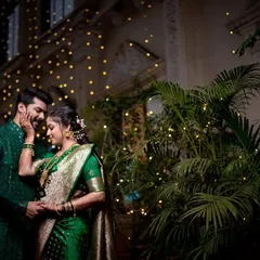 An intimate portrait of a newly engaged couple in stunning green traditional outfits. The fairy lights in the background add a magical, celebratory feel.