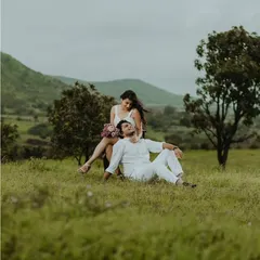A romantic moment in the lush green meadows of Nashik. The vast, open landscape and dramatic sky create a perfect setting for a peaceful couple photoshoot.