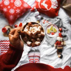 My Christmas mood is officially on! A flatlay from my perspective, enjoying hot chocolate in bed surrounded by festive cushions and decor. This type of shot creates a personal and relatable holiday vibe.