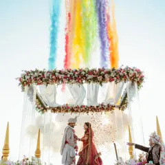 Nothing hits different than a Goa wedding. We created this magical Varmala moment with a floral arch against the sky, using colored smoke to paint the clouds and make the moment truly unforgettable for the couple.