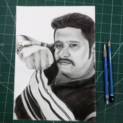 The finished portrait for a client from Karnataka, shown on my work mat next to the pencils I used to create it.