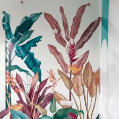 This close-up shows the detail of a vibrant, hand-painted style tropical wallpaper. The mix of colorful leaves and flowers can turn any plain wall into a lively and artistic focal point.
