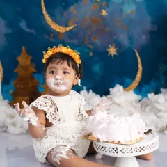 A celestial celebration for a little star turning one. Covered in cake with a dreamy moon and stars backdrop, this moment is pure, messy magic.