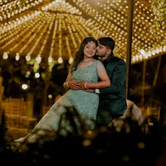 I love using creative lighting to create a magical atmosphere for evening events. Here, a canopy of fairy lights provides a warm, romantic glow for an intimate reception portrait, highlighting the couple's connection.