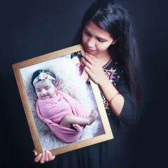 Another example of a finished product, with a mother holding a framed portrait of her baby girl. I offer custom framing and albums to turn your digital photos into lasting art.