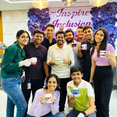 Work hard, create harder. This team proudly shows off the custom mugs they designed during a corporate workshop, a great way to foster creativity and teamwork in the workplace.
